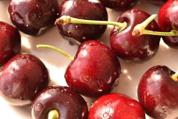 Fresh, ripe organic cherries arranged on a plate, perfect for a healthy, natural snack