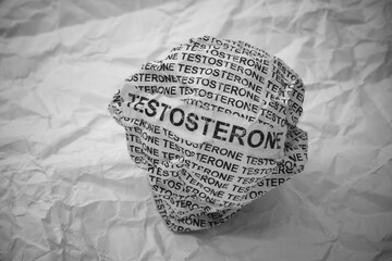Crumpled paper ball with words Testosterone on crumpled white paper background