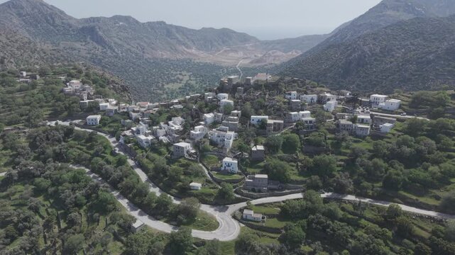 Aerial drone footage of Emporeios village revealing volcanic caldera behind it. Tight shot filmed with 3x telephoto lens in D-Log M profile