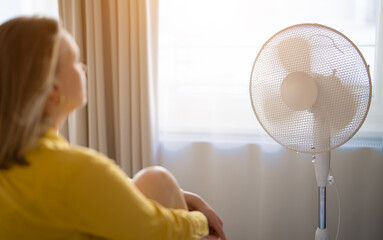 Woman suffering from extreme summer heat indoors.