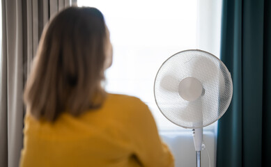 Woman suffering from extreme summer heat indoors.
