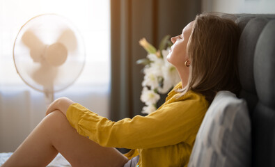 Woman suffering from extreme summer heat indoors.