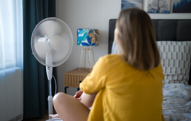 Woman suffering from extreme summer heat indoors.