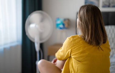 Woman suffering from extreme summer heat indoors.