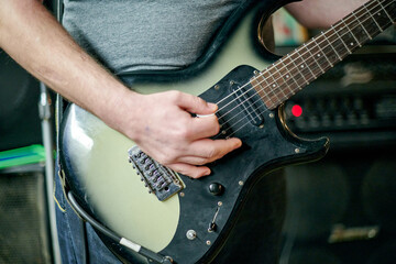 Close up of musician hands playing an electric bass guitar, focusing on precise finger placement and frets during practice session performance