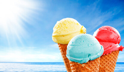 Colorful Fruit Scoop Ice Cream Cone Against Blue Sky on Hot Summer Day - hot summer and beach vibes. Refreshing scene perfect for summer treats, vacation, seaside fun and vacation lifestyle concepts.