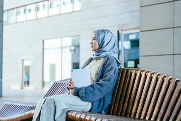 Focused Millennial Muslim Woman Holding Tablet on City Bench