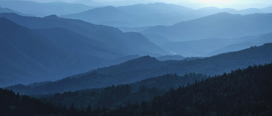 Obraz premium Beautiful panorama of morning blue mountain landscape. Horizontal image.