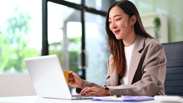Asian business woman typing laptop and tablet Placed at the table and modern workplace lifestyle themes.