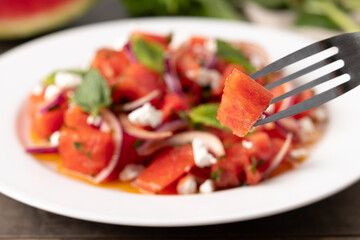 Fresh Watermelon Feta Salad with Mint and Red Onion on wooden table
