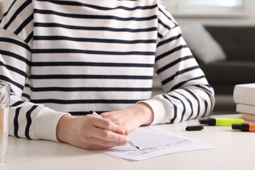 Woman underlining important information with marker at white desk indoors, closeup