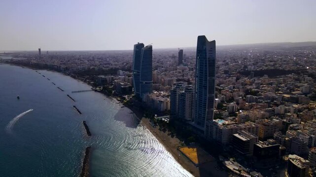 Evening sunset over Limassol, Cyprus. Aerial view of modern urban architecture and glass skyscrapers of Cyprus. Mediterranean Sea near Limassol, Cyprus. High quality footage 4k