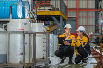 Factory apprenticeship. Man mentor teaching Female employees trainee operating machine looking...