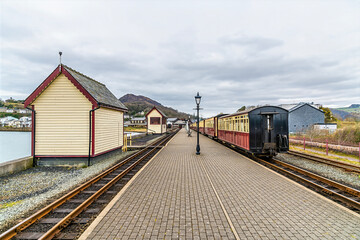 Obraz premium A view from the end of the platform towards the railway station at Porthmadog, Wales in springtime 
