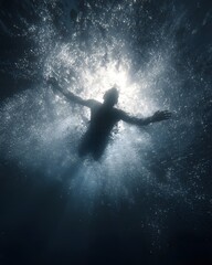 A silhouette of a swimmer breaking the surface of water, illuminated by sunlight from above