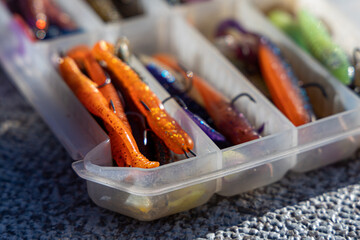 Fishing tackles and fishing baits in box .Classic Colored Fishing Lure , Beautiful Background digital image.Fishing on the lake at sunset.