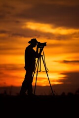 Silhouette of a photographer capturing a sunset landscape with vibrant colors and dramatic clouds