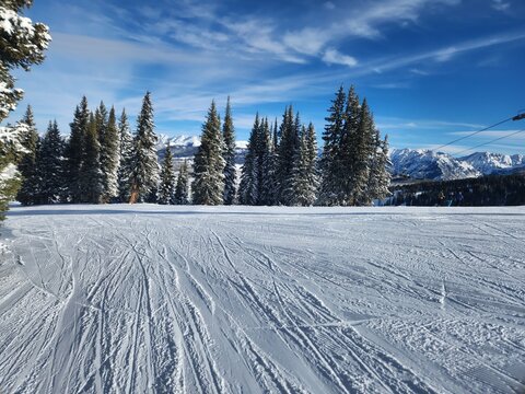 Pristine snow slopes in Colorado, blanketed in powdery white snow, inviting skiers and snowboarders to carve their way through the winter wonderland of the Rocky Mountains.