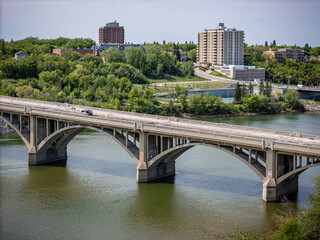 Bridge spans a river with a city in the background