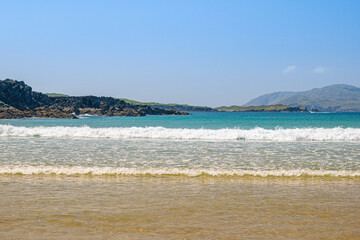 Bright beach surrounded by rocks in sunny weather, Seskin Island, Baltimore, Ireland