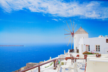 white windmill of Oia at sunny day with blue sea and sky close up, Santorini