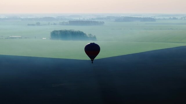 Early spring light, fog embrace farmland horizon as balloon floats over Latvia