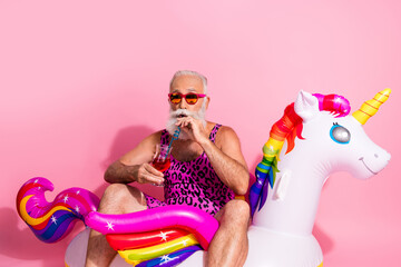 Vibrant summer scene with elderly man enjoying vacation on unicorn float wearing leopard print...