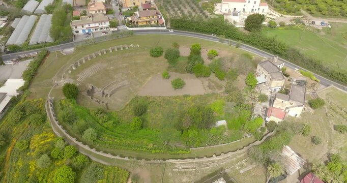 Aerial view of the Roman Amphitheatre in the archaeological site of Cuma in the province of Naples, Campania, Italy. It is an amphitheatre built by the ancient Romans in the old town of Cumae.