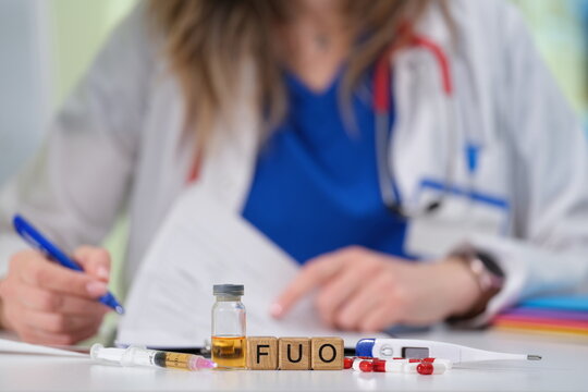 A healthcare worker documents a fever of unknown origin using a vial and supplies for accurate analysis