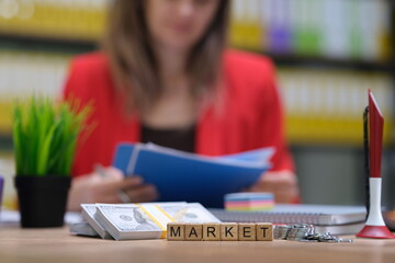 A focused woman meticulously reviews important reports in a vibrant and energetic office,...