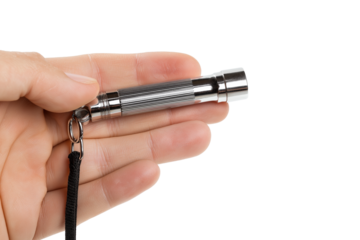 Hand holding small silver whistle isolated on white background