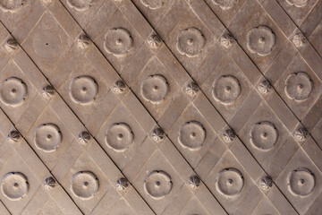 Ornate studded metal surface with geometric pattern and circular embellishments