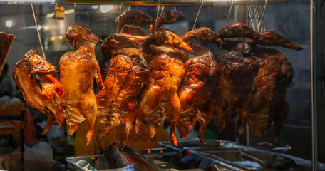 Perking Ducks Hanging In A Restaurant Viewed Through Glass Door