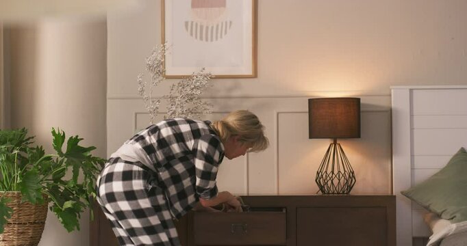 Woman, dresser and search item in home with stress, lost clothing and desperate for garment. Back, angry and person with depression in bedroom for outfit rummage, chaos or annoyed with mental health