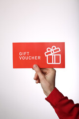 Top view of woman holding gift voucher lettering on white background