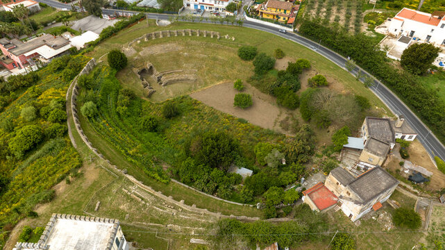 Aerial view of the Roman Amphitheatre in the archaeological site of Cuma in the province of Naples, Campania, Italy. It is an amphitheatre built by the ancient Romans in the old town of Cumae.