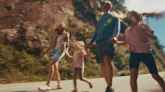 Family travel. Young family with kids walk fast on the road in the narrow canyon and explore new destination all together