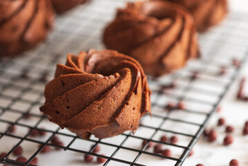 Mini chocolate bundt cakes on a cooling rack. Soft focus