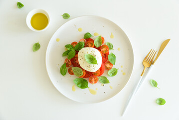 Fresh Caprese salad with mozzarella, tomatoes, and basil, served with bread.