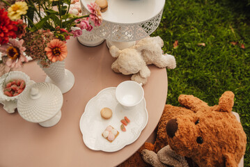 Child's tea party set with stuffed animals and snacks