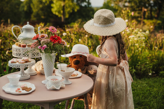 Little Girl having a tea party with a teddy bear