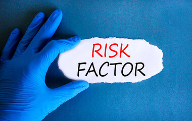 Risk factor symbol. Concept words Risk factor on beautiful white paper. Doctor's hand in blue...