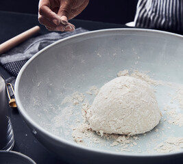 Close-Up of Hand Preparing Dough in Mixing Bowl