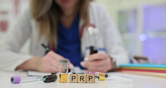 Abbreviation PRP on wood blocks with blood samples on lab desk. Doctor research platelet rich plasma in medicine and cosmetics usage in hospital