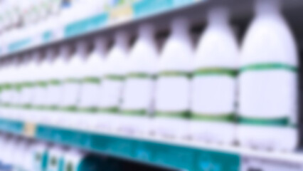 Blurred image of bottles of Milk, yogurt. Defocused supermarket shelves. Retail industry. Local Farmers market. Grocery store. product. Food. stall. Family shop. Dairy products. Inflation concept.