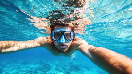 Naklejka premium Underwater selfie of a man snorkeling in clear turquoise water.