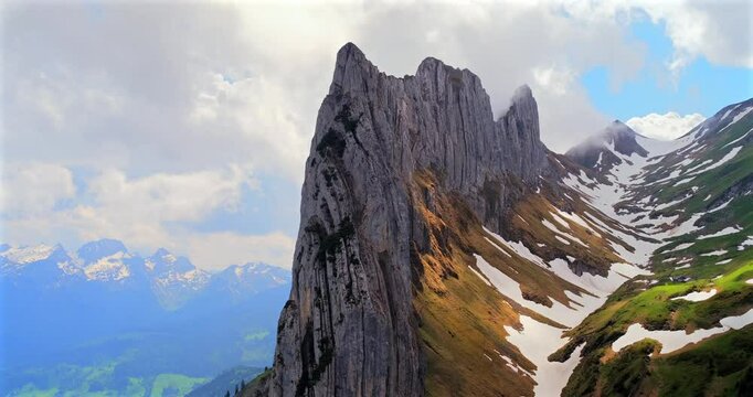 Stunning mountain cliffs rise dramatically against a vibrant sky in the Swiss Alps