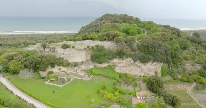 Aerial view of the archaeological excavations of Cuma, in the province of Naples, Campania, Italy. On the hill are the remains of the ancient city of Cumae, one of the oldest Greek colonies in Italy.