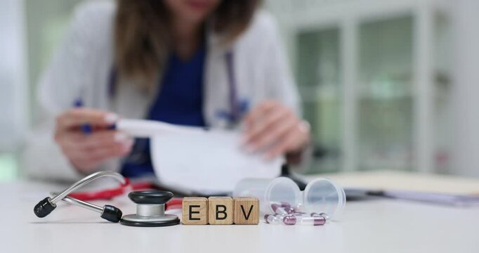 Medical worker holds thermometer and checks patient temperature while working with EBV shown on cubes. Treatment of Epstein Barr virus in hospital