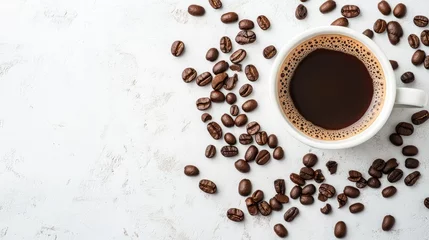 Fotobehang Cup of coffee seen from above with scattered beans on white surface © Lasvu